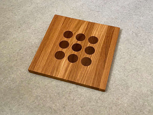 Square cutting and serving board in white oak with 9 inlaid walnut dots like tic tac toe.
