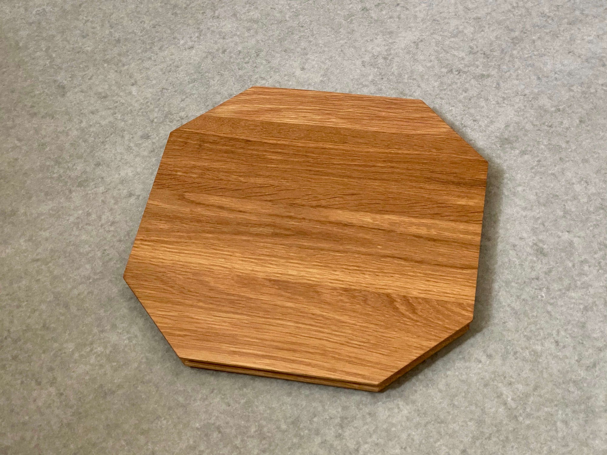Octagonal shaped cutting and serving board made of cherry. Sculpted edges provide comfortable fingerholds.