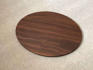 Oval shaped cutting and serving board in walnut. Sculpted edges provide comfortable fingerholds.