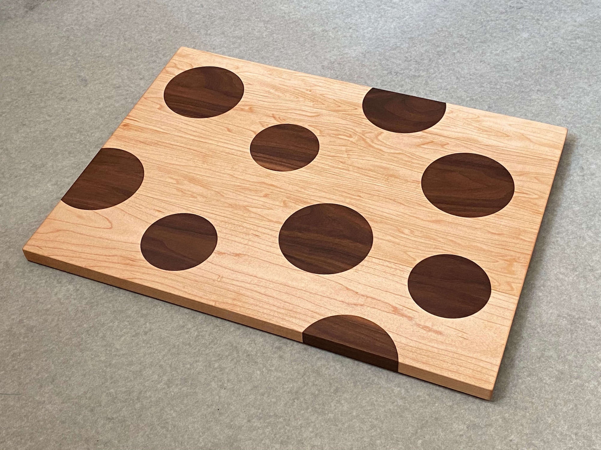 Large rectangular cutting and serving board of mahogany with large inlaid maple dots. Pattern is on both sides.