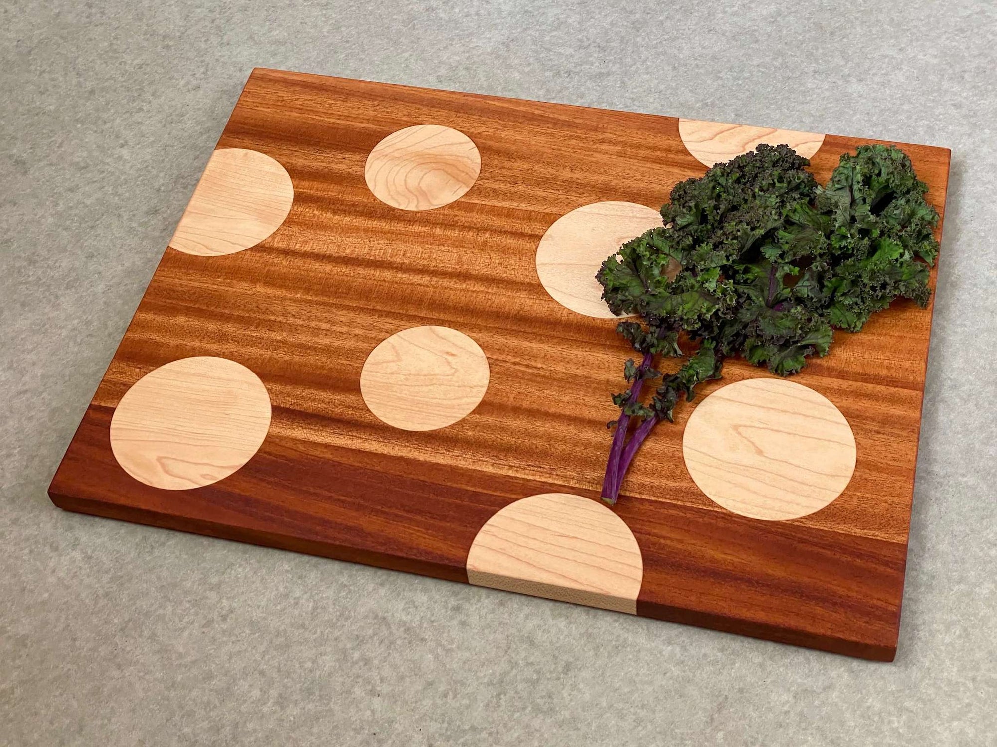 Large rectangular cutting and serving board of mahogany with large inlaid maple dots. Pattern is on both sides.
